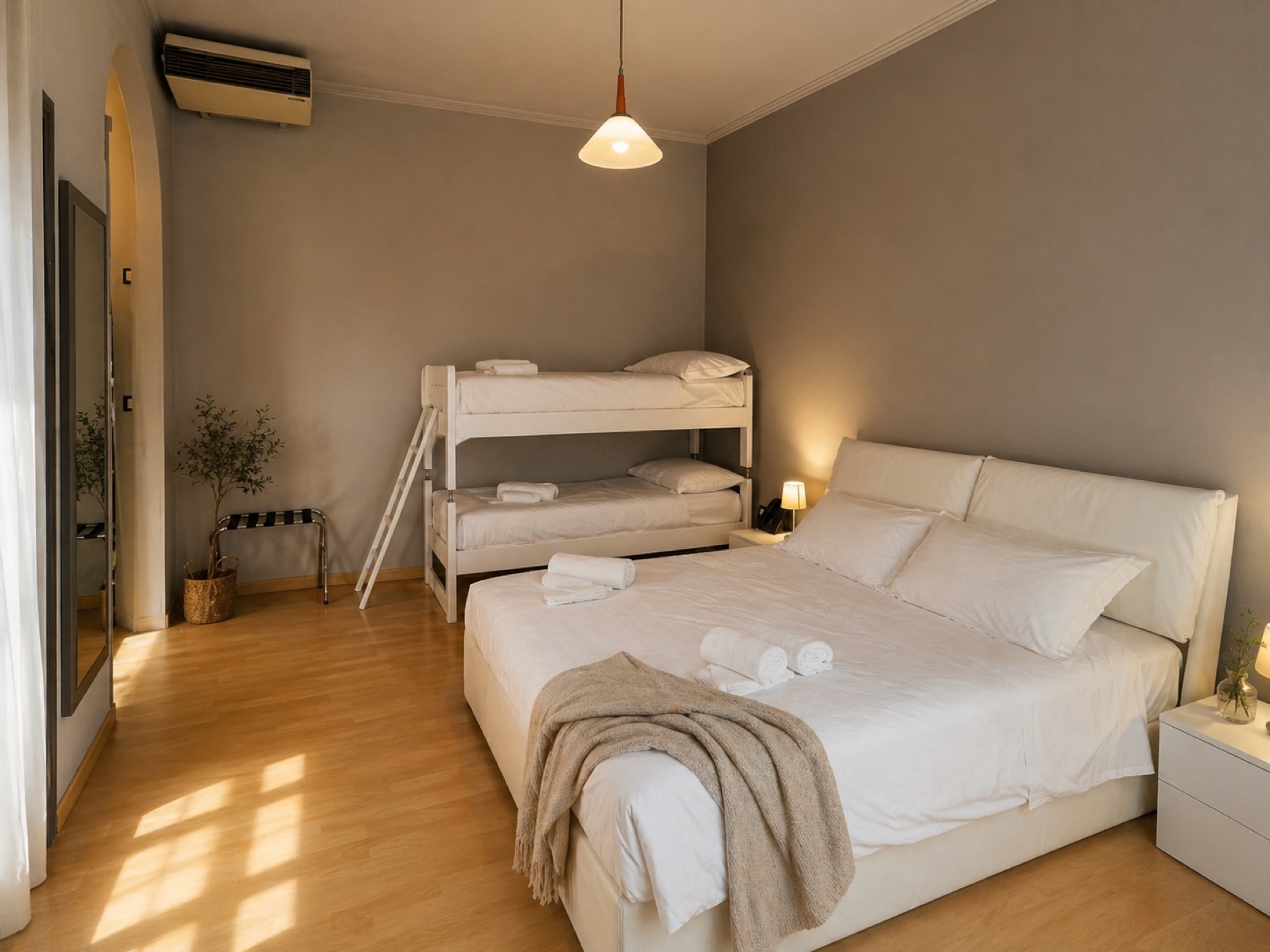 Camera famigliare con letto matrimoniale e letto a castello, parquet e pareti chiare